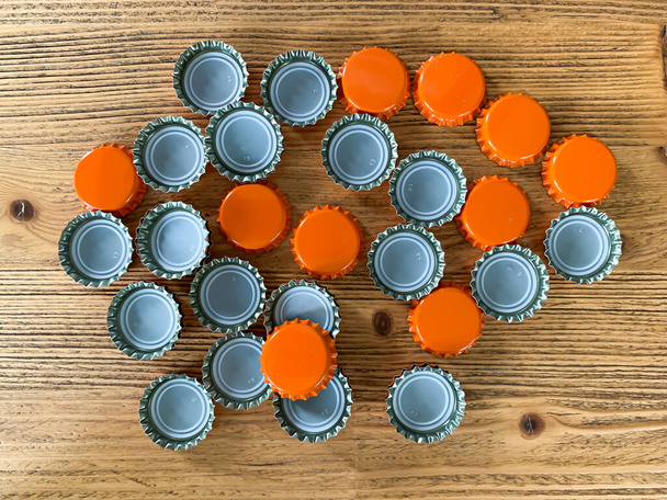 Wiele pomarańczowe pokrywy piwa, korki butelki topy na drewnianej tekstury widok z góry obraz poziomy  - Zdjęcie, obraz