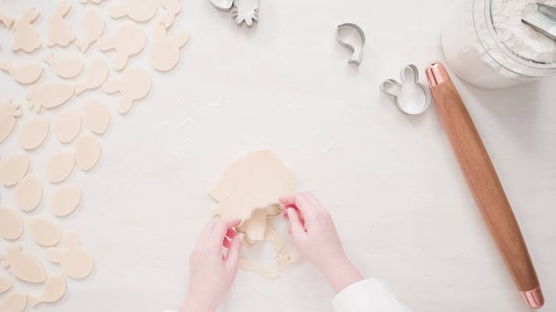 Step by step. Flat lay. Cutting sugar cookie dough with Easter shaped cookie cutters. - Zdjęcie, obraz