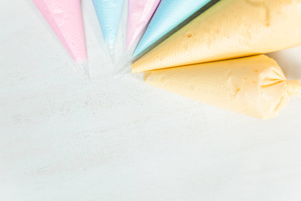 Sacchetti di tubazioni con glassa reale color pastello per decorare biscotti di zucchero pasquali
. - Foto, immagini