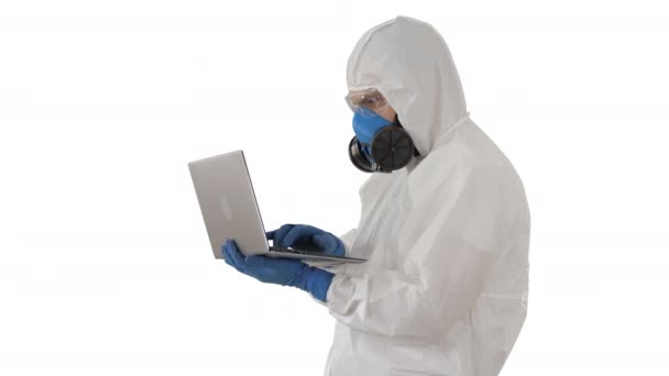 Medical doctor in white protective uniform using laptop on white background. - Felvétel, videó