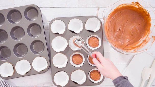 Deitado. Escavar massa nos forros de cupcake de papel alumínio para assar cupcakes de framboesa de chocolate. - Foto, Imagem
