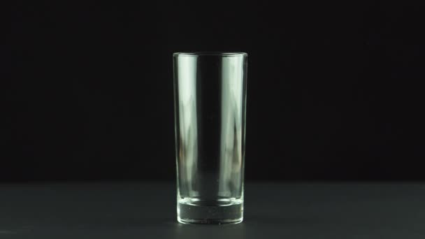 Suco derramando em vidro isolado no fundo preto
 - Filmagem, Vídeo