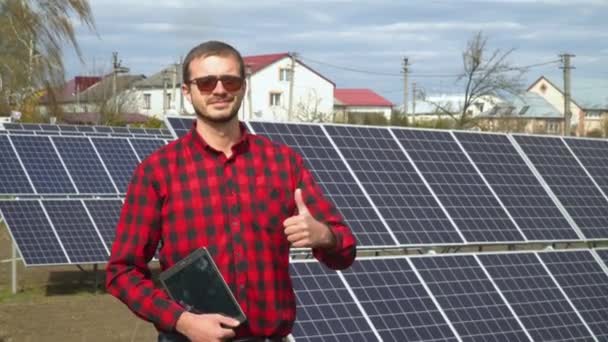 Portrait of a young engineer on the background of a solar power station - 映像、動画