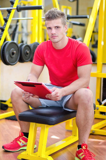 Young male personal trainer holding clipboard - Foto, immagini