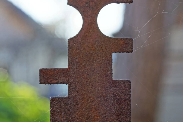 vieja placa marrón de hierro oxidado en una telaraña en la calle
 - Foto, Imagen