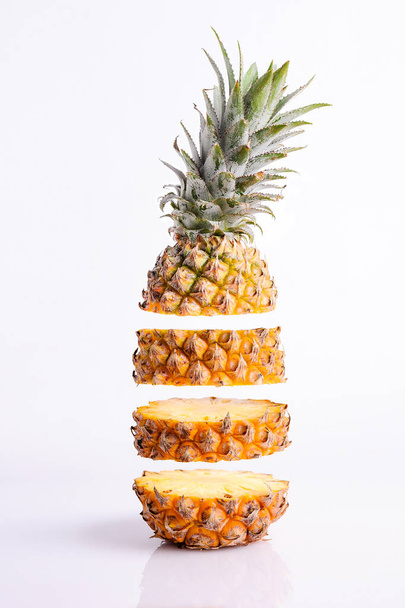 Afbeelding van Flying Fresh Ripe Ananas Slices, geïsoleerd op witte achtergrond - Foto, afbeelding