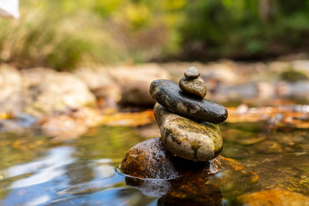 A kövek Zen tornyokban vannak elhelyezve a folyómeder mellett egy nyári napon. - Fotó, kép