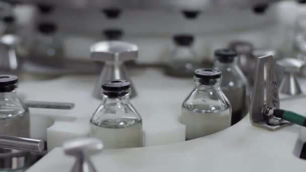 glazen flessen op een transportband voor medische oplossing bij tankstation close-up - Video