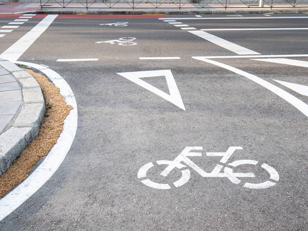 Segnaletica stradale dipinta a terra nella città di Madrid, corsia con una bicicletta dipinta e un cartello di resa, con due moto dipinte sull'asfalto prima di un attraversamento zebra
 - Foto, immagini