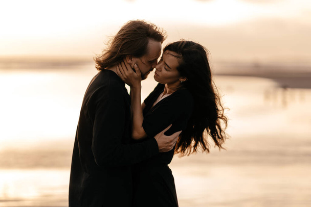 Attractive man and woman enjoying romantic evening on sunset - Fotografie, Obrázek