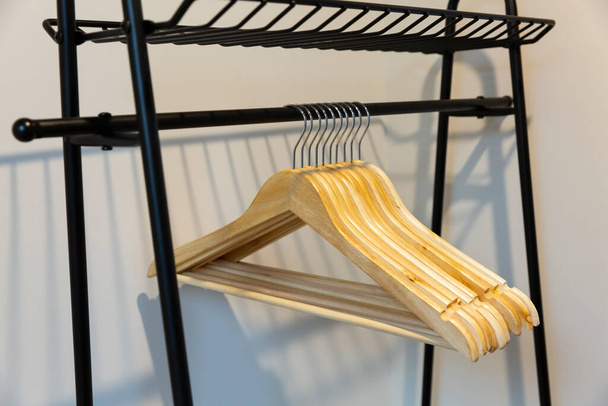 Schnappschuss eines Kleiderbügels, der an einem Kleiderbügel zum Aufbewahren von Kleidung hängt - Foto, Bild