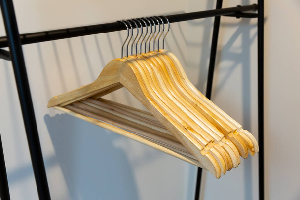 Schnappschuss eines Kleiderbügels, der an einem Kleiderbügel zum Aufbewahren von Kleidung hängt - Foto, Bild