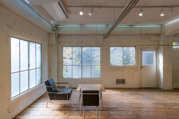 Un espacio interior retro con grandes ventanas en forma de vid y suelos de madera vintage
 - Foto, Imagen
