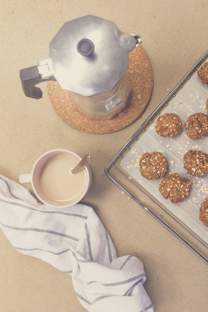 topview homemade oat cookies, coffee cup and moka pot on light background - Photo, Image