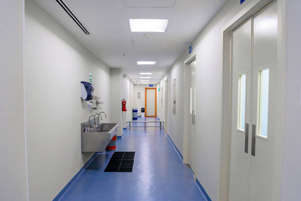 Διάδρομος στο νοσοκομείο μπροστά από το χειρουργείο με μονάδα υγιεινής Μπλε πάτωμα. - Φωτογραφία, εικόνα