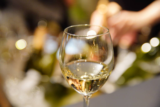 Γκρο πλαν φωτογραφία ποτηριού κρασιού τοποθετημένου στον χώρο του πάρτι - Φωτογραφία, εικόνα