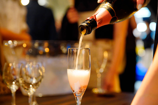 Игристое вино налито в бокал на месте проведения вечеринки
 - Фото, изображение