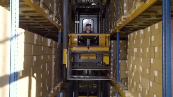 Carretilla elevadora paletas móviles con cajas de cartón en un almacén con bastidores de gran altura
 - Metraje, vídeo