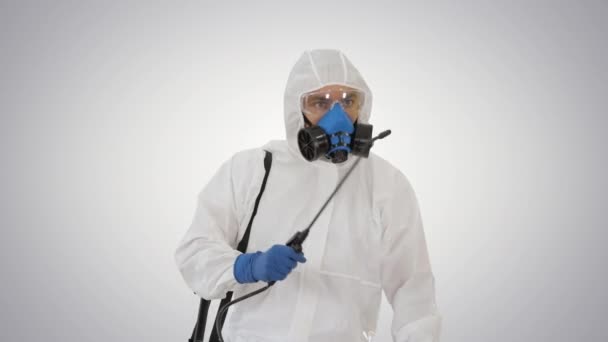 Wirusolog w mundurze ochronnym chodzący i dezynfekujący obszar na tle gradientowym. - Materiał filmowy, wideo