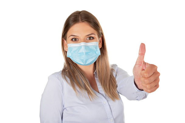 Caucasian woman with surgical mask showing thumbs up on isolated background - Fotografie, Obrázek