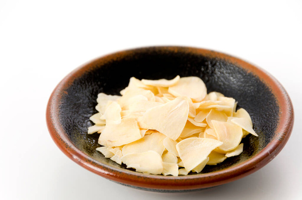 scaglie di aglio essiccate su piattino
 - Foto, immagini
