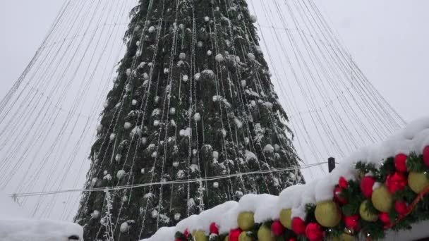 Kerstboom met decoraties op de achtergrond van een besneeuwde stad. 4K - Video