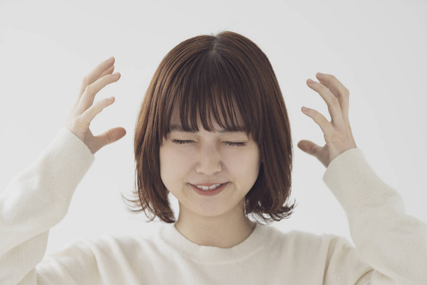 Uma jovem asiática (japonesa) que franze a testa e expresse emoções raivosas
 - Foto, Imagem