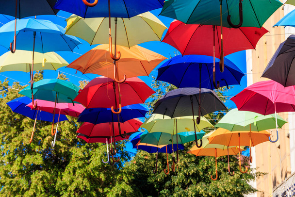 Paraguas multicolor en la calle de la ciudad. La calle de la ciudad está decorada con muchos paraguas abiertos de colores - Foto, imagen
