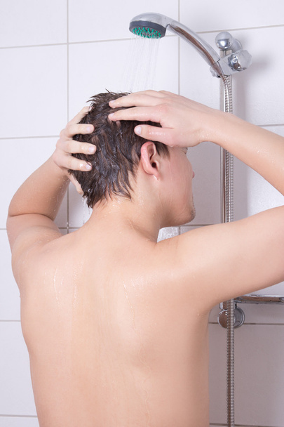 vonzó fiatalember fejét a fürdőszobában mosógép - Fotó, kép