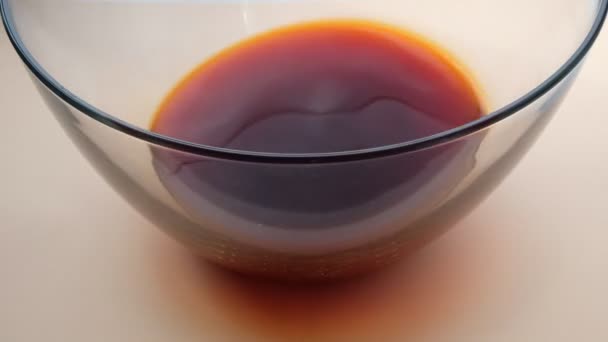 Glass bowl with natural onion dye of Lush Lava Color. The solution shakes. - Footage, Video