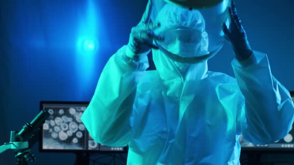 Wissenschaftler in Schutzanzügen und Masken arbeiten im Forschungslabor mit Laborausrüstung: Mikroskope, Reagenzgläser. Coronavirus covid-19 Hazard, pharmazeutische Entdeckung, Bakteriologie und Virologie - Filmmaterial, Video