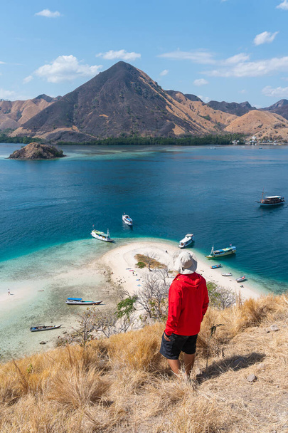 A traveller standing on top of Kelor island in Flores island, Komodo national park in Indonesia, Asia - Photo, image