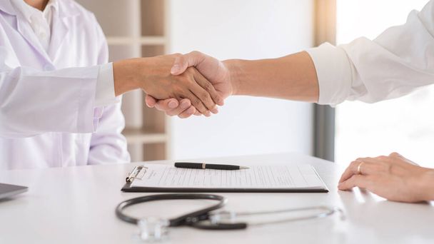 Attractive Doctor and patient shaking hands for encouragement and empathy, healthcare and assistance, Medical concept - Φωτογραφία, εικόνα