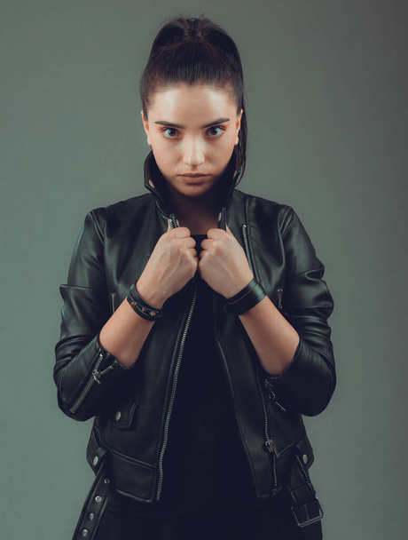 Portrait of young beautiful woman with black leather jacket ,on grey background - Foto, Imagen