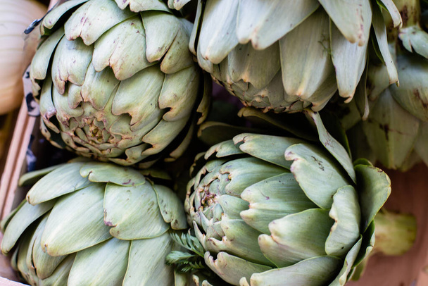 counter with artichoke on the vegetable market in europe - 写真・画像