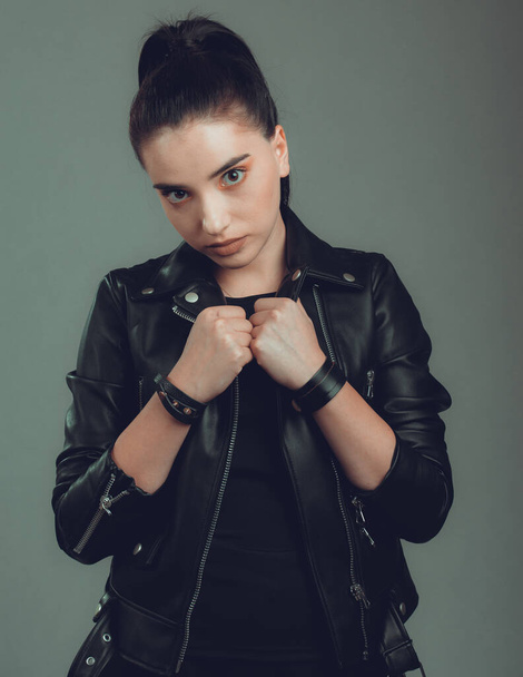 Portrait of young beautiful woman with black leather jacket,on grey background - Foto, immagini