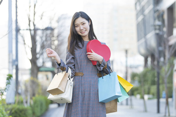 色々な色のショッピングバッグがたくさんある笑顔アジアの若い女性 - 写真・画像