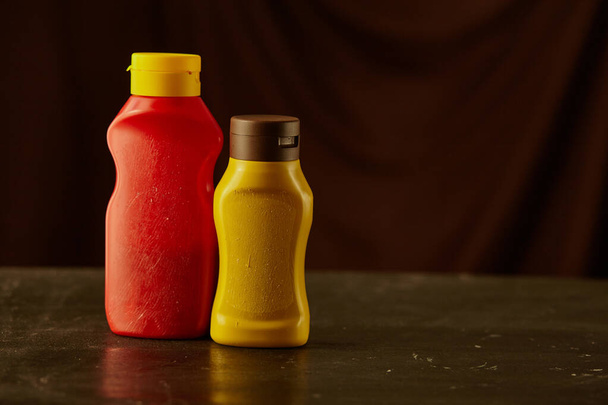 Eine Flasche Ketchup und Senf auf der schwarzen mit Kopierraum - Foto, Bild