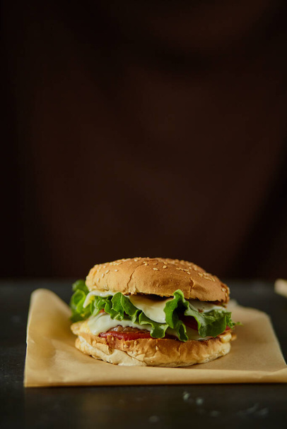 Burger con l'ingrediente sulla scrivania in legno nero
 - Foto, immagini
