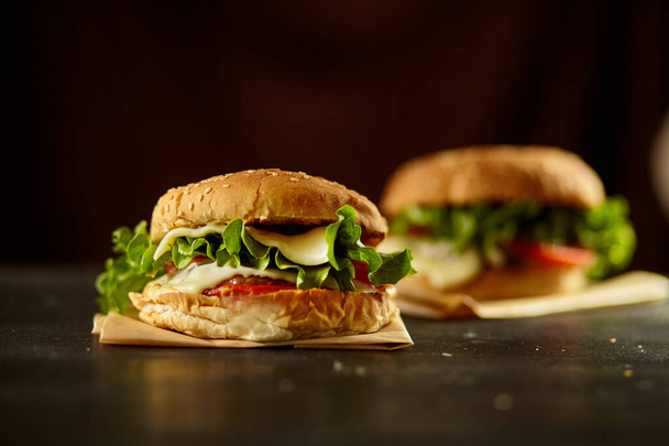 Burger mit Zutat auf dem schwarzen Holztisch - Foto, Bild