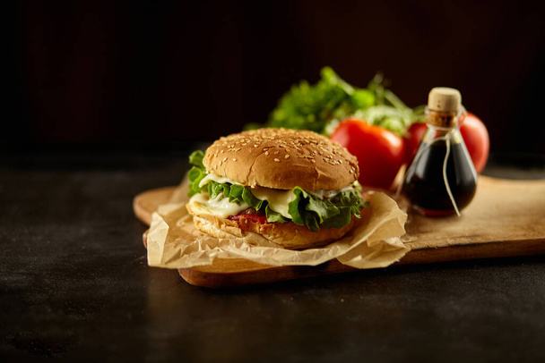 Hamburguesa con el ingrediente en el escritorio de madera negro
 - Foto, Imagen