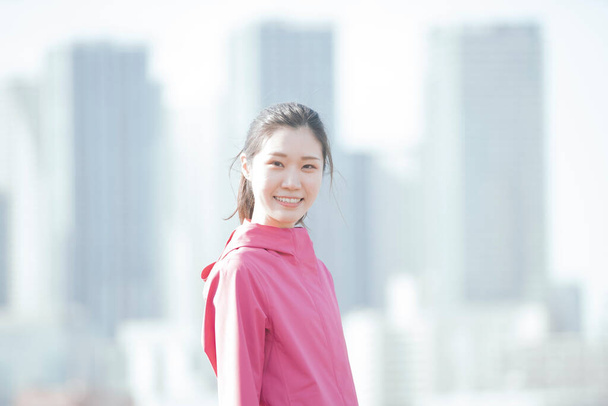 Asiática joven mujer de negocios ejercicio en el centro de la ciudad en un día soleado
 - Foto, imagen