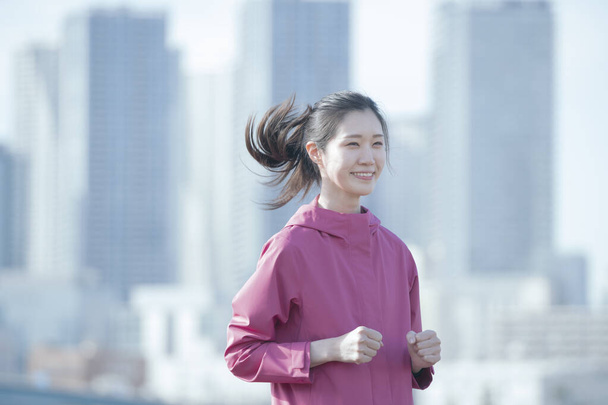 Asiática joven mujer de negocios ejercicio en el centro de la ciudad en un día soleado
 - Foto, Imagen