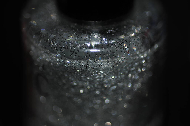 Макро фото лака для ногтей бутылки с жидкими блестками 1
 - Фото, изображение