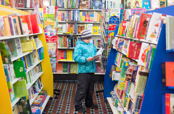 The boy chooses a book in the shop - Photo, image