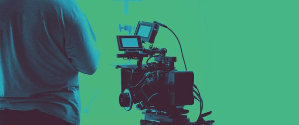 Barevné záběry zákulisí natáčení týmu filmových štábů a HD kamerového vybavení ve studiu, které zahrnuje stativ, soft box světlo, monitory, objektiv pro natáčení filmu nebo filmu nebo živé vysílání - Fotografie, Obrázek