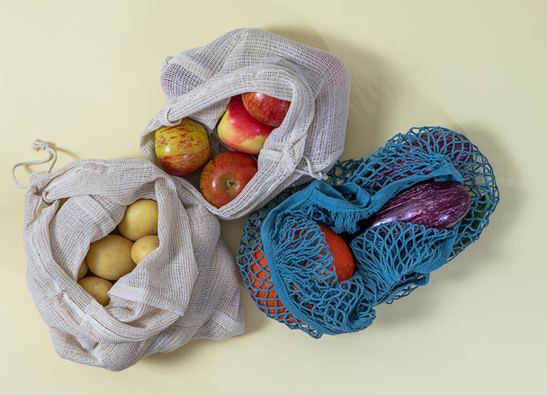 Zero waste shopping. Various textile bags with fruits and vegetables. Top view - Fotó, kép
