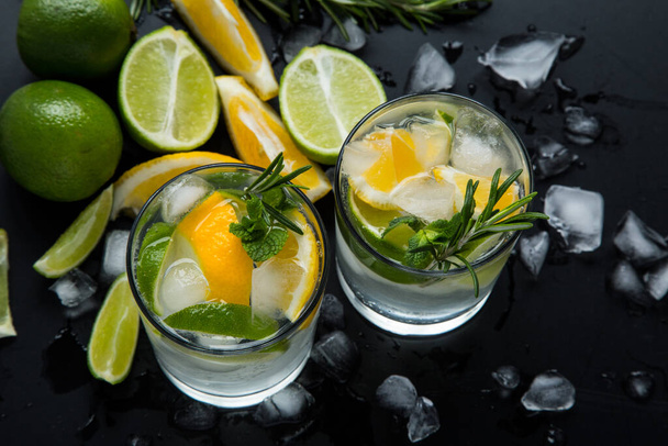 Cocktail de verão fresco com limão e gelo na mesa preta
 - Foto, Imagem