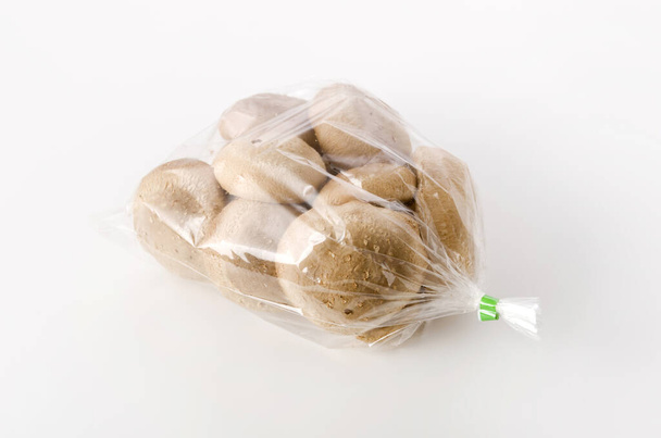 Beyaz arka planda şeffaf plastik torba içinde Shiitake mantarı - Fotoğraf, Görsel