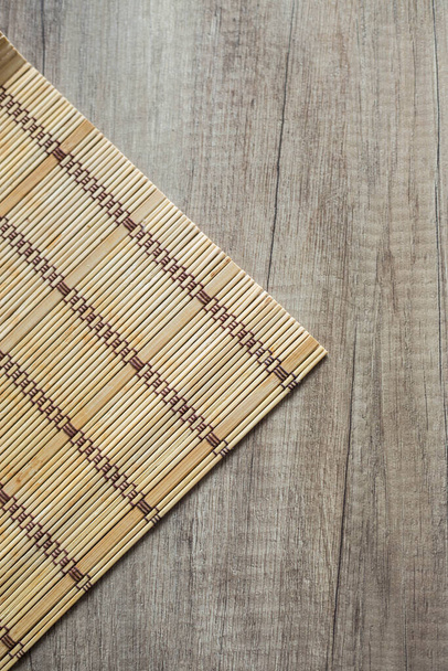 Bamboe mat op de houten tafelservet op een houten plank home decor en comfort - Foto, afbeelding